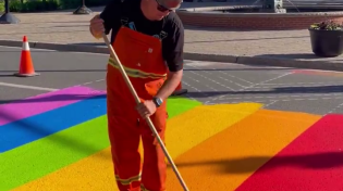 Thumbnail for "Downtown Fredericton is looking a little brighter this morning as City crews paint the PRIDE sidewalk in front of City Hall. 🌈 This is one small step on our long road together toward a more inclusive and safe society for all!."  Check out the paint roller